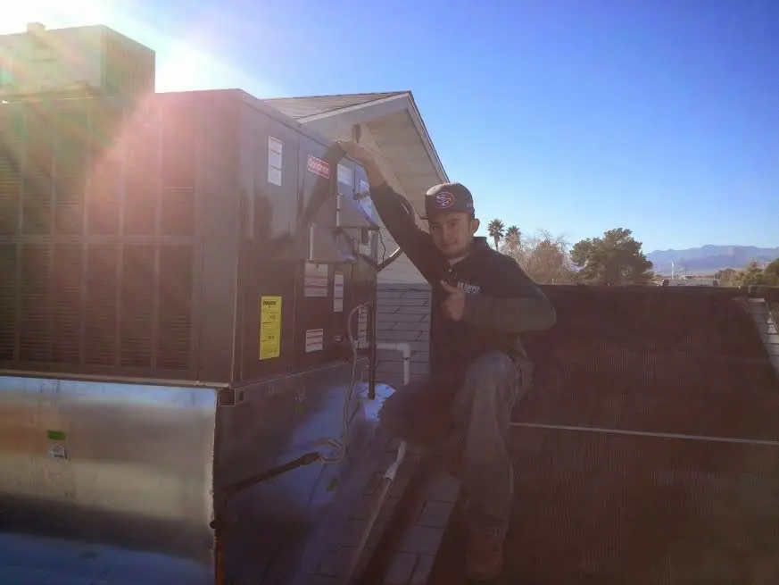 HVAC technician performing AC Tune-Up on a rooftop unit in Gladstone